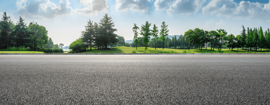 asphalt road with trees in background