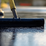 man sealcoating driveway